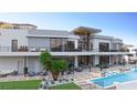 Luxury home boasts an outdoor living area with a pool, seating, and balconies at 1487 Reims Dr, Henderson, NV 89012