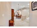 View of the entryway looking toward a dining room with a chandelier and a wooden table at 6143 Basilone Ave, Las Vegas, NV 89122