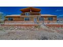Rustic log home exterior with a deck and landscaping at 561 Miranda Rd, Pahrump, NV 89060
