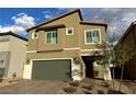 Charming two-story house featuring a green garage door and paved brick driveway at 7156 Woodrow Ranch St, Las Vegas, NV 89166