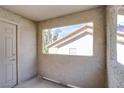 Private balcony featuring textured walls and a view of a neighboring building through a cut-out window at 4200 S Valley View Blvd # 3030, Las Vegas, NV 89103