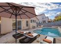 Relaxing backyard with a swimming pool, lounge chairs, and lush landscaping at 7936 Pinnochio Ave, Las Vegas, NV 89131