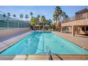 Inviting community pool surrounded by palm trees and lounge seating at 5301 River Glen Dr # 210, Las Vegas, NV 89103