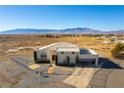 Two-story house with attached garage and large yard in a desert setting at 3490 S Adobe Ct, Pahrump, NV 89048