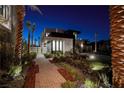 Striking two-story home with lush landscaping and a modern facade at twilight at 500 Overlook Rim Dr, Henderson, NV 89012