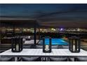 Inviting outdoor dining area with a pool and stunning panoramic city views at night at 500 Overlook Rim Dr, Henderson, NV 89012