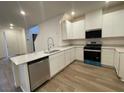 Modern kitchen features white cabinets, stainless steel appliances, and a breakfast bar at 2723 Luzzi Walk, Henderson, NV 89044