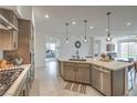 Bright kitchen showcasing a gas cooktop, stainless steel appliances, an island with seating, and sleek countertops at 617 Sylvan St, Henderson, NV 89002