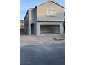 Two-story home featuring a gray stucco exterior, a two-car garage, and a window overlooking the street at 6574 Tumoulin St, Las Vegas, NV 89148