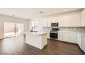 Modern kitchen boasts white cabinets, stainless steel appliances, and a center island at 9881 Lost Horse Ave, Las Vegas, NV 89178