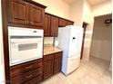 View of kitchen with built-in oven, refrigerator, and wooden cabinets at 3004 Darby Falls Dr, Las Vegas, NV 89134