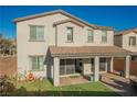 Home's back exterior shows a covered patio and manicured backyard, ideal for outdoor gatherings and relaxation at 35 Flora Sagio Ave, Henderson, NV 89011