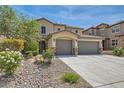 Inviting two-story home features a three-car garage and desert landscaping in the front yard at 3605 Sapphire Sea Ct, North Las Vegas, NV 89031