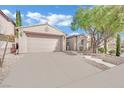 Charming home with a well-manicured lawn, a two-car garage, and mature trees at 952 Contadero Pl, Las Vegas, NV 89138