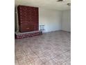 Spacious living room features tiled flooring and a brick fireplace, offering a comfortable and stylish space at 1604 Luning Dr, Las Vegas, NV 89106