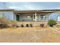 View of backyard showing covered patio and potential for landscaping with mature tree at 2510 N Woodchips Rd, Pahrump, NV 89060