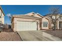 Tan house with a white garage door and gravel driveway at 3456 Beca Faith Dr, North Las Vegas, NV 89032