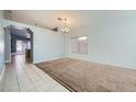 Spacious living room features neutral carpet, lots of natural light, and a decorative chandelier at 3456 Beca Faith Dr, North Las Vegas, NV 89032