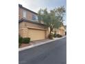 Tan two-story house with attached garage and partial view of neighboring house at 10753 Cather Ave, Las Vegas, NV 89166