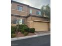 Two-story house with tan exterior, attached garage, and landscaped front yard at 10753 Cather Ave, Las Vegas, NV 89166