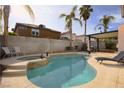 Backyard featuring a sparkling pool, spa, tanning deck, patio and shade structure, perfect for outdoor entertaining at 8737 Autumn Valley Ave, Las Vegas, NV 89129