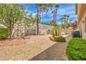 Spacious backyard featuring low-maintenance landscaping, a stone retaining wall, and mature trees at 1590 Sabatini Dr, Henderson, NV 89052