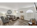 Living room features gray couch, recliner, wood-look floors, and large windows at 3145 E Flamingo Rd # 1045, Las Vegas, NV 89121