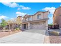 Two-story house with a beige exterior, two-car garage, and landscaping at 5484 Oatfield St, North Las Vegas, NV 89081