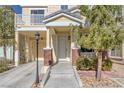 Charming yellow two-story home with a balcony, attached garage, and landscaped front entrance at 1676 Tristan Flower Ave, Las Vegas, NV 89183