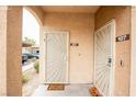 A condo entrance featuring tan stucco, unique doors, and desert landscaping at 2151 Hussium Hills St # 207, Las Vegas, NV 89108