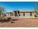 Tan colored stucco home with a tile roof and landscaping at 3780 Shawnee Ave, Pahrump, NV 89048