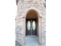 Double front doors with arched entryway and stone surround at 5527 Breecher Ave, Las Vegas, NV 89131