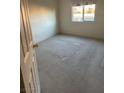 Simple carpeted bedroom with window and ceiling fan at 5521 Little Lake Ave, Las Vegas, NV 89122