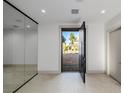 Bright foyer features sleek tile flooring and a modern glass partition, creating an open and inviting space at 19 Rue Grimaldi Way, Henderson, NV 89011