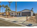 Single-story home with a dark brown garage door and palm trees at 3698 Rawhide Ct, Las Vegas, NV 89120