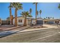 Updated single-story home with a landscaped front yard, featuring palm trees and a water fountain at 3698 Rawhide Ct, Las Vegas, NV 89120