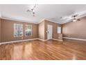 Open-concept living room with hardwood floors, large windows, and neutral wall color at 1053 Plentywood Pl, Henderson, NV 89002