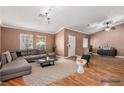 Staged living room featuring a gray sectional sofa, patterned rug, and hardwood floors at 1053 Plentywood Pl, Henderson, NV 89002