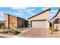 Contemporary home with a two-car garage and brick paver driveway at 16 Via Stefano, Henderson, NV 89011