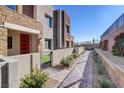 Landscaped walkway leading to modern townhome entrances at 600 N Carriage Hill Dr # 1113, Las Vegas, NV 89138