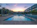 Serene community pool at dusk, surrounded by lounge chairs and modern architecture at 353 E Bonneville Ave # 313, Las Vegas, NV 89101