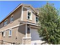 Two-story house with attached garage, stone accents, and tree at 112 Antler Square Ln, Henderson, NV 89011