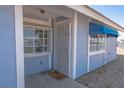 Charming condo exterior featuring light blue siding, secure door, and awning over the window at 5409 Centurion Ct # 104, Las Vegas, NV 89122