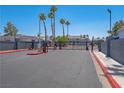 Gated entrance to the Duck Creek Village community with mature palm trees on a sunny day at 5409 Centurion Ct # 104, Las Vegas, NV 89122