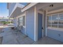 Exterior view of a condo with light blue siding, a covered patio, and three chairs at 5409 Centurion Ct # 104, Las Vegas, NV 89122