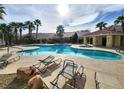 Enjoy the community pool with lounge chairs surrounded by lush palm trees at 6409 Sierra Diablo Ave, Las Vegas, NV 89130