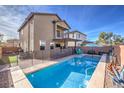 Inviting backyard pool surrounded by privacy fencing with a covered patio area and sunny blue skies at 6482 Twin Harbors Ct, Las Vegas, NV 89141