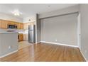 Open-concept space featuring hardwood floors and views of the kitchen with stainless steel appliances at 7701 Himalayas Ave # 104, Las Vegas, NV 89128