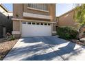 Front exterior featuring a two-car garage with a wide driveway, desert landscaping, and neutral paint at 7936 Dexter Falls St, Las Vegas, NV 89149