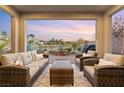 Covered patio with wicker furniture and fire pit at 23 Papavero Ct, Henderson, NV 89011